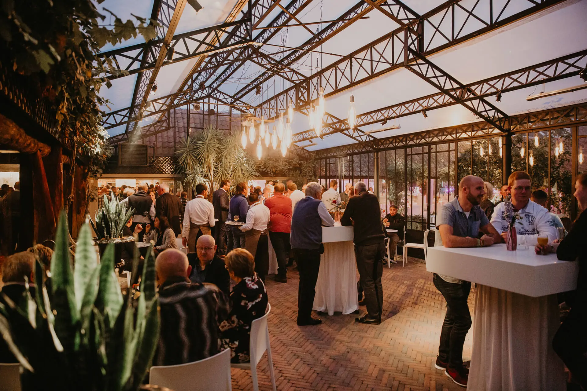 Receptie aan statafels in de orangerie van de grote zaal
